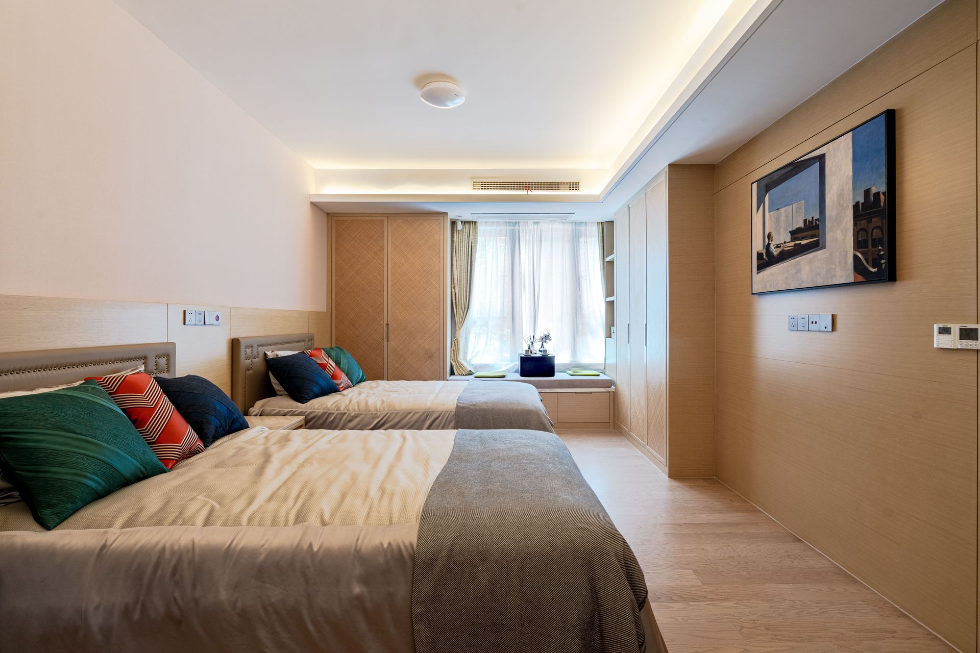 A well-organized minimalist bedroom with twin beds and elegant decor.